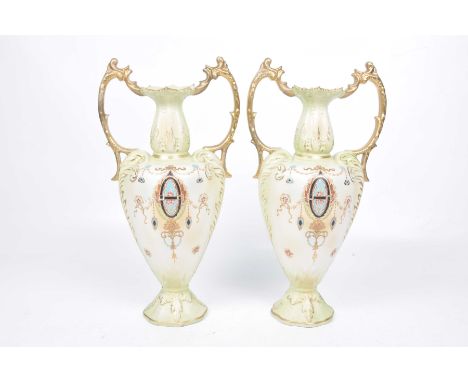 A pair of late Victorian W. Adams & Co Tunstall blush ivory vasesEach of twin handled pedestal form, rising from a spreading 