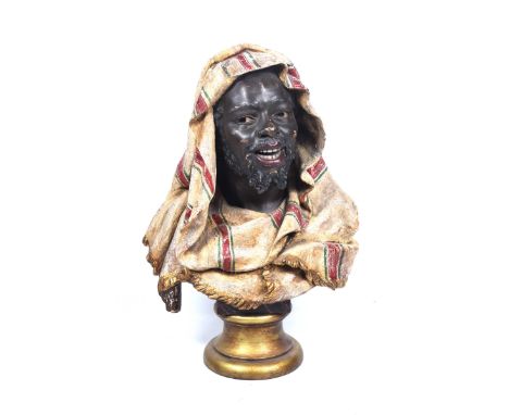 A Goldscheider style bust of a Middle Eastern manRaised on a socle and plinth base, the figure with jovial expression, his he