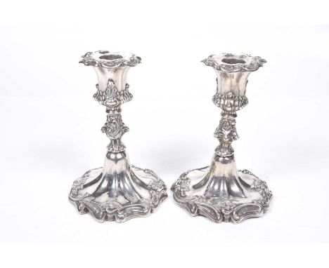 A pair of Victorian silver candlesticksThe nozzles with chased decoration, to a knopped stem, terminating on circular fluted 