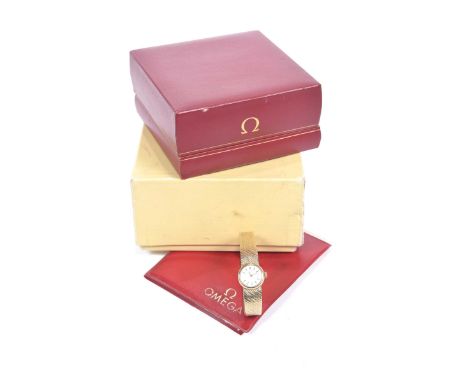 Omega: A Ladies 9k gold manual wind bracelet watchThe silvered dial with applied baton hour markers fitted to a 9k gold textu