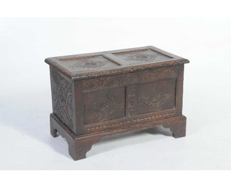 A 17th Century style oak cofferOf small proportions, the rectangular top with two panels each centred with a flower head with