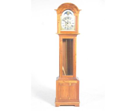 A reproduction hardwood long case clock by Mike Brown & MillerThe break arch dial with a silver chaptering and four subsidiar