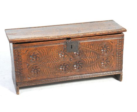A 17th Century oak six plank cofferThe rectangular hinged top with two channels above a front panel carved with flower heads 