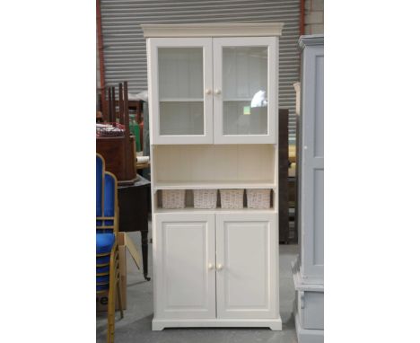 A contemporary white housekeepers cupboardWith a moulded cornice above a pair of glazed doors, a single open shelf and a pair