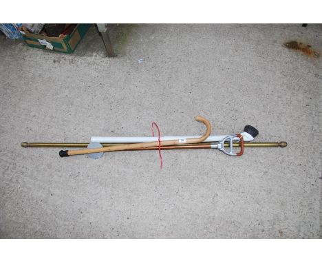 A brass curtain pole, shooting stick, walking stick, etc.