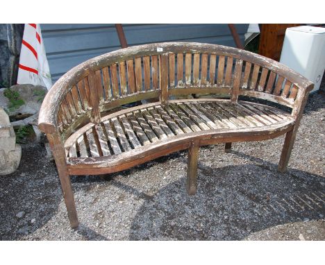 A carved back wooden bench, 62'' wide x 32 1/2'' high x 21'' deep.