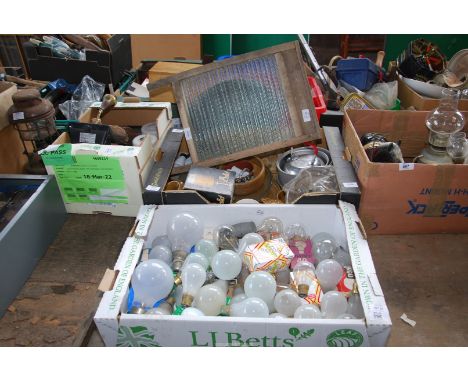 An old wash board, box of light bulbs, kitchen ware and glass ware lamp shades and security lights.