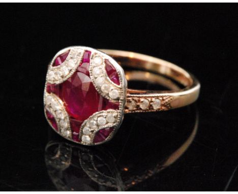 A 15ct Art Deco style rose gold ruby and diamond cluster ring, the shaped rectangular panel head centred by an oval mixed cut