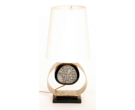 A circa 1970s table lamp with a rectangular base mounted with a brush finish brass tear drop column with abstract tonal grey 