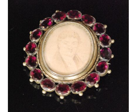 A 19th Century gilt metal swivel portrait brooch with a plaited hair panel to reverse, all within a red paste set border, len