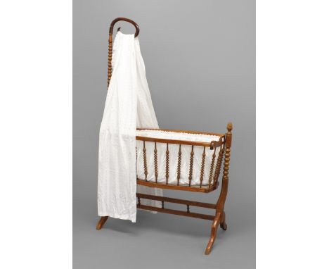 A FRENCH CHILD'S ROCKING CRIB, the shepherd's crook top on a bobbin-turned column above the crib with further turned spindles