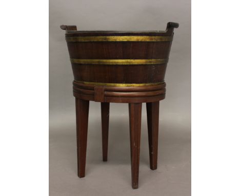 A GEORGE III MAHOGANY AND BRASS BOUND JARDINIERE, of oval form with raised handles, on a later stand, height 53cm
