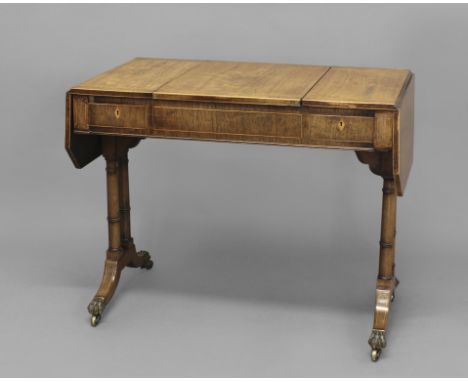 A REGENCY ROSEWOOD DROP LEAF GAMES TABLE, the shaped rectangular top with boxwood stringing and amboyna inlaid borders above 