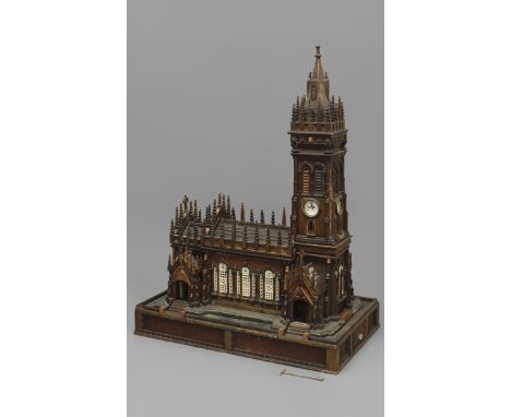 A COIN-OPERATED WOODEN SCALE MODEL OF A CHURCH, with carved turrets and spires and inlaid decoration, the bell tower with pla