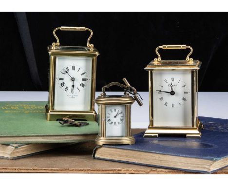 Three brass carriage clock timepieces, one small oval example, 7.5cm high, a larger example marked Reid & Son Paris, a newer 