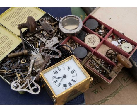 A collection of clock and watch spare parts and related items, including a small brass carriage clock, a vacant silver pocket