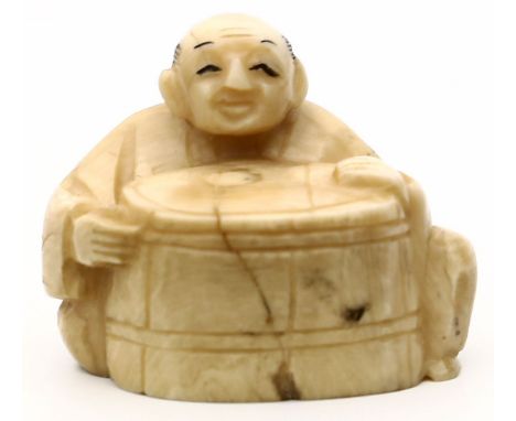 Netsuke. Hinter Fass sitzender Mann. Hirschhorn. Spannungsriss. Japan. H. 3,2 cm.