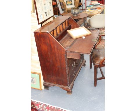 A mahogany Georgian and later small slant top bureau, multi drawer ffitted interior above four graduated drawers, on ogee bra