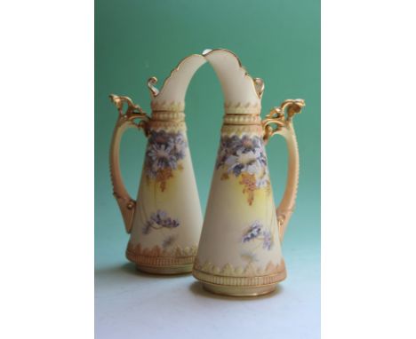 A pair of Royal Worcester ivory ground ewers, with hand painted floral decoration, 21cm high