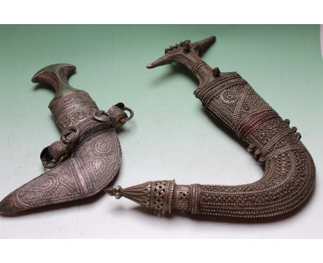 Two Eastern white metal mounted Jambiya, one with script plaque on rear of scabbard