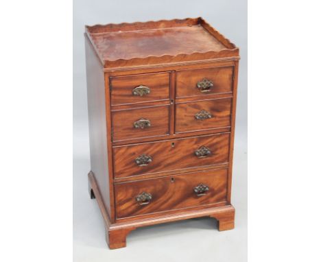 A George III mahogany gallery top nightstand, with faux drawer cupboard over two graduated drawers, on bracket feet