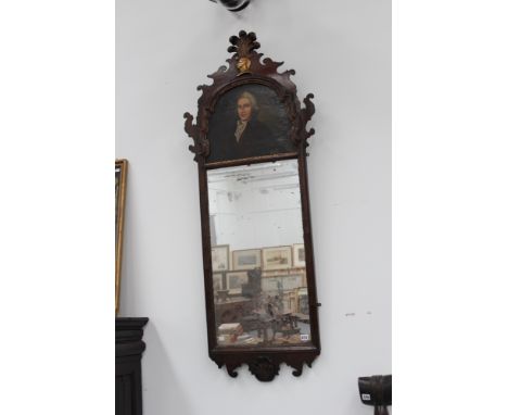 An antique carved and gilt walnut pier mirror, the shaped fret cut crest panel with painted portrait, surmounted by a plumed 