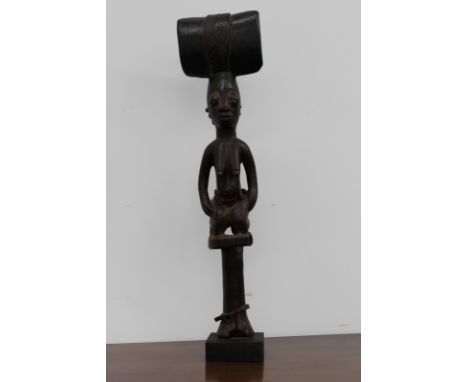 A carved ceremonial tribal staff finial of figural female form, possibly African, 61cm high.
