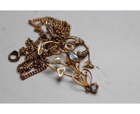 An Art Nouveau 9ct openwork pendant, set with zircon and seed pearls, on gilt chain