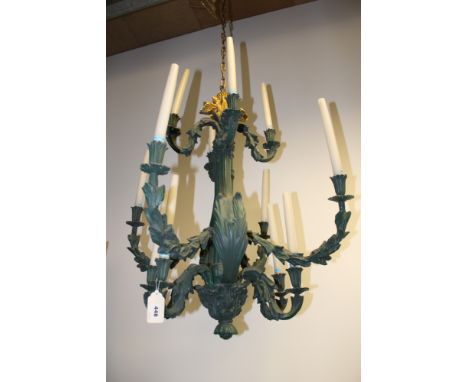 A pair of Rococo style verdigris twelve light chandeliers, with foliate scroll arms, 80cm high