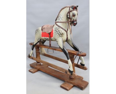 A vintage child's rocking horse: a dappled grey mounted on trestle form base, 114cm high x 128cm wide
