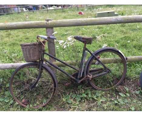 A Vintage trade bike featuring a bell and pump with a basket on the front.