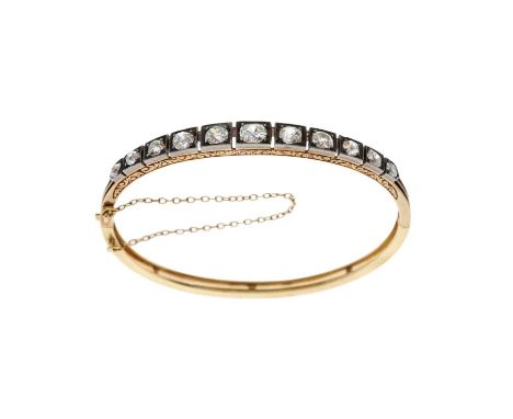 A late Victorian gold and silver, graduated old-cut diamond hinged bangle bracelet, with scrolling engraved sides, estimated 