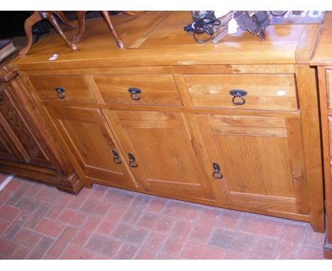 A light oak sideboard with three drawers and cupboards under - width 140cm 
