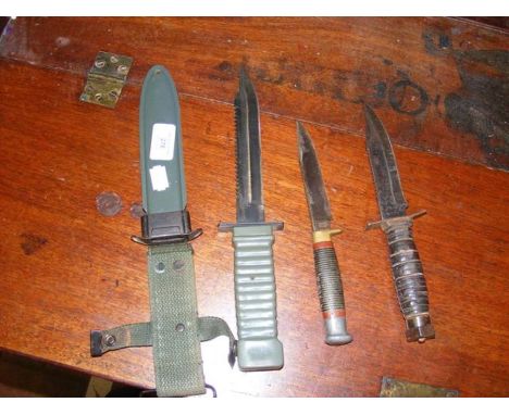 An old army dagger with scabbard together with two other daggers