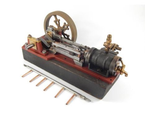 A partial horsepower live steam table top stationary engine, driven by a part pierced 24cm dia., drive wheel moving articulat
