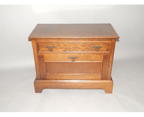 An oak side cabinet, fitted with a shallow drawer and lockable front, on bracket feet, 85cm wide.