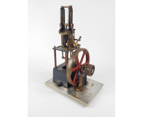 A scratch built table top Steeple engine, with 16cm dia. drive wheel moving various brass pistons, etc., on a metal base, 39c