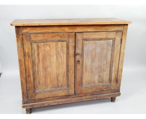 A Victorian pine cupboard, with two doors enclosing a single shelf, raised on turned feet, 130cm x 46cm x 108cm.