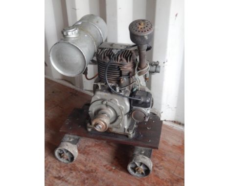 A mid 20thC Lister stationary engine no. W11742, 1250 rotations per minute, 1ABL, with name plate on truckle base, 62cm high.