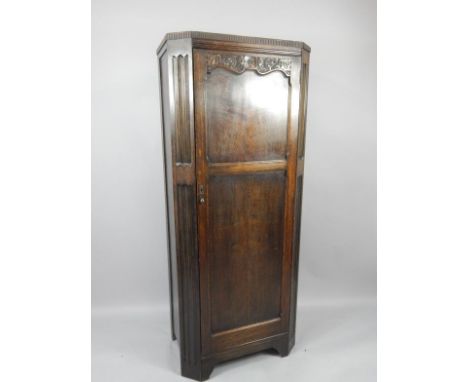 An oak early 20thC hall cupboard, with floriate carving, single door, raised on bracket feet, 75.5cm x 45cm x 184cm.