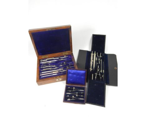 A set of Army & Navy late 19thC steel and ivory drawing instruments, walnut cased, and two further cased sets of drawing inst