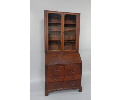 A George III and later oak bureau bookcase, marriage, the top with two glazed doors enclosing four shelves, over a fall flap 