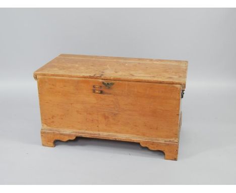 A pine chest, with brass lock plate, raised on bracket feet, replacement studded lid,  96cm x 47cm x 53cm.