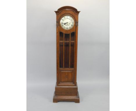 An early 20thC oak cased grandmother clock, silvered dial bearing Arabic numerals, eight day triple barrel movement with West