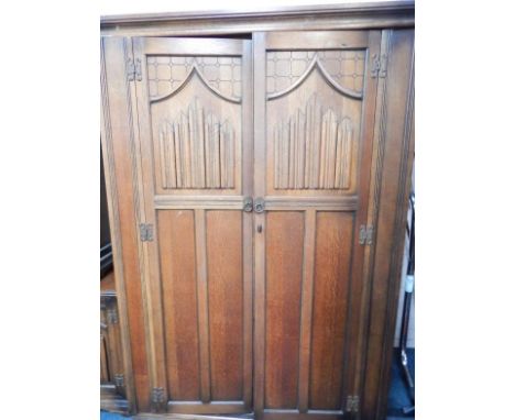 An Old Charm oak double wardrobe, with a pair of linenfold panelled doors, raised on a bracket base, 125cm x 52cm x 186cm.