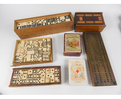 Two sets of 19thC bone dominoes, later set, two cribbage boards, card game of Spelling Bee and a set of Charles Goodall & Son