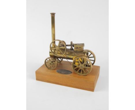A 20thC miniature table model of a Thomas Aveling traction engine, in brass, with articulated parts, 15cm wide, on wooden bas