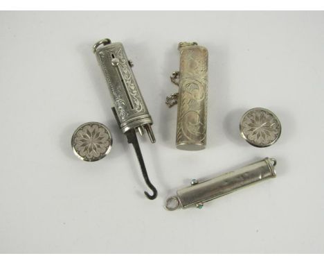 A silver needle case, silver button hook and pencil combination, silver pendant necessaire, and two silver studs.