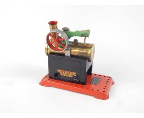 A Mamod stationary engine, with brass cylinder, 12cm wide. and articulated flywheel on part pierced base.