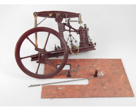 A scratch built partial horsepower live steam engine, in purple with 28cm dia. drive wheel and articulated pistons on a plain